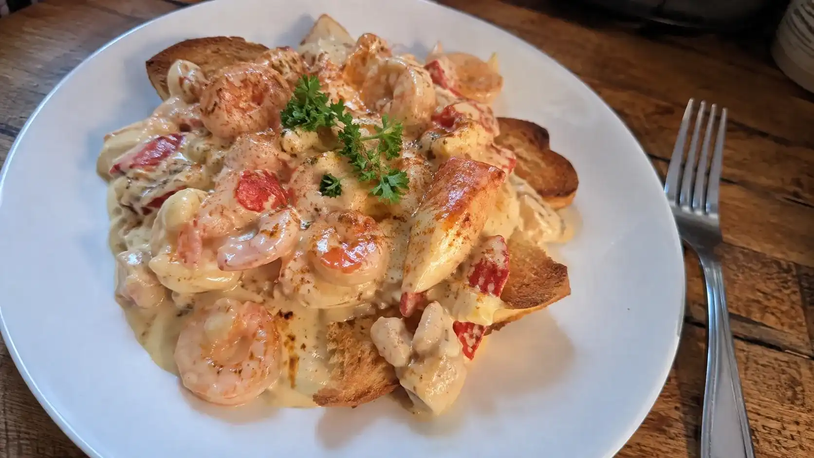 Creamy seafood Newburg with shrimp, crab, and lobster served over toast points