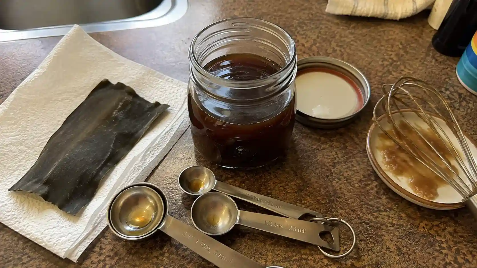 vegan fish sauce substitute recipe in a glass jar with miso and kombu