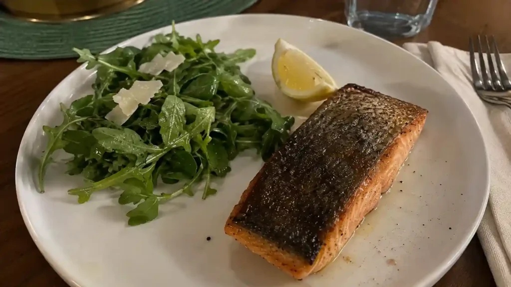 plated pan-seared salmon with salad and lemon