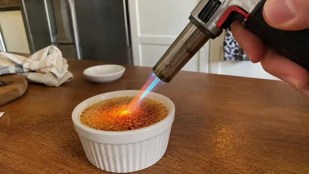 Caramelizing the sugar topping on crab brulee with a kitchen torch